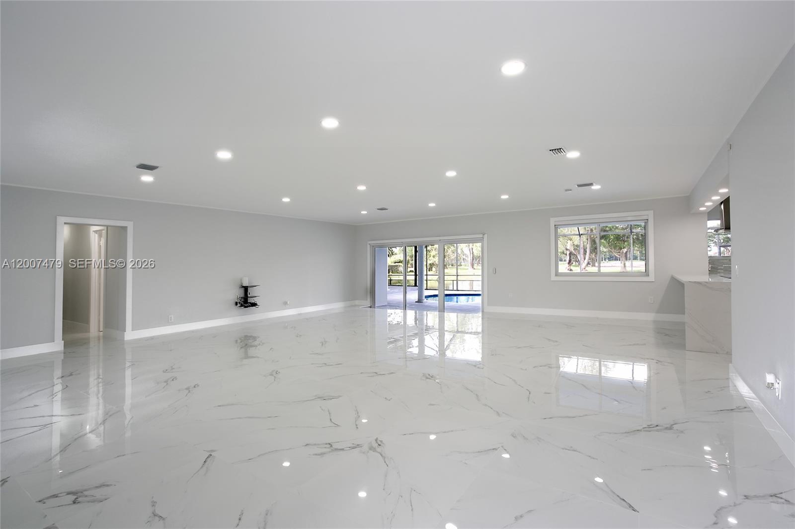 A spacious, open-concept living area features white marble-look tile flooring and recessed ceiling lighting — 19150 S Saint Andrews Dr, Hialeah FL 33015, HIALEAH, FL