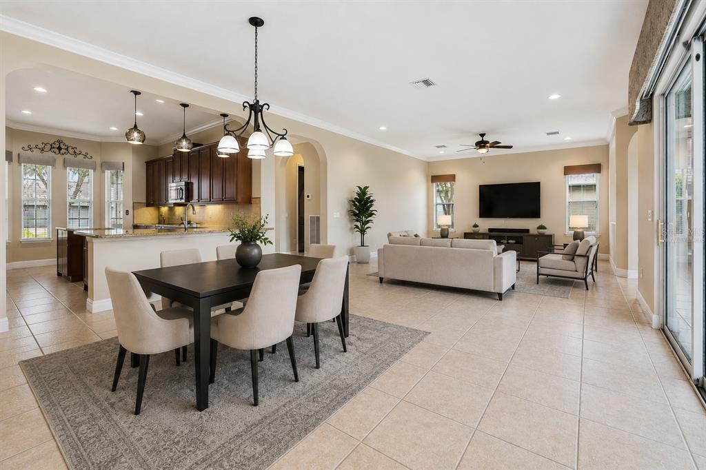 An open-concept living and dining area features tile flooring, neutral walls, and dark wood cabinetry — 228 BAYOU BEND ROAD, GROVELAND, FL