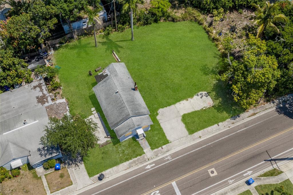 An aerial view shows a small house situated on a large, grassy corner lot — 2001 15TH AVENUE S, ST PETERSBURG, FL