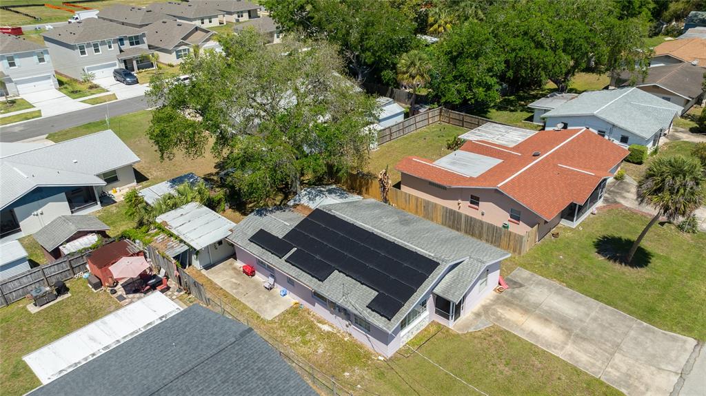 An aerial view shows a single-story house with solar panels on its roof — 1107 4TH STREET, PORT ORANGE, FL