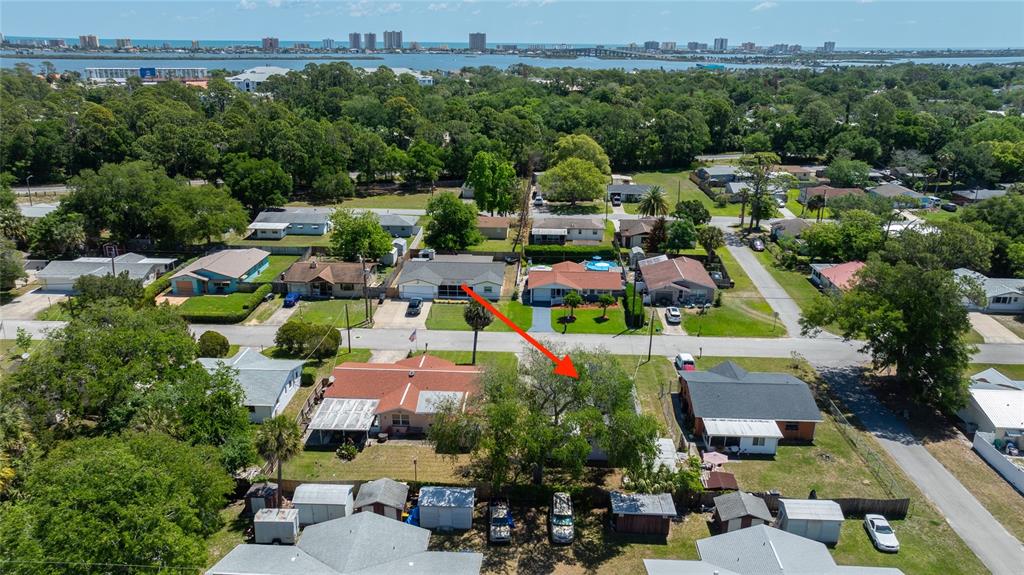 An aerial view shows a residential neighborhood with a red arrow pointing to a house — 1107 4TH STREET, PORT ORANGE, FL