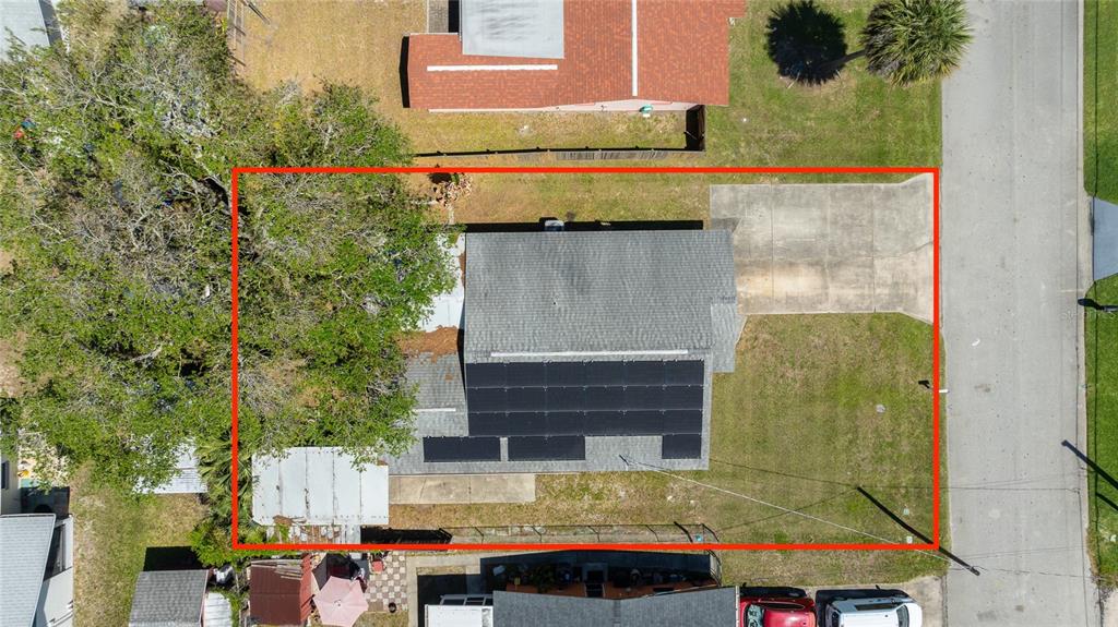 An aerial view shows a house with solar panels on the roof and a driveway — 1107 4TH STREET, PORT ORANGE, FL