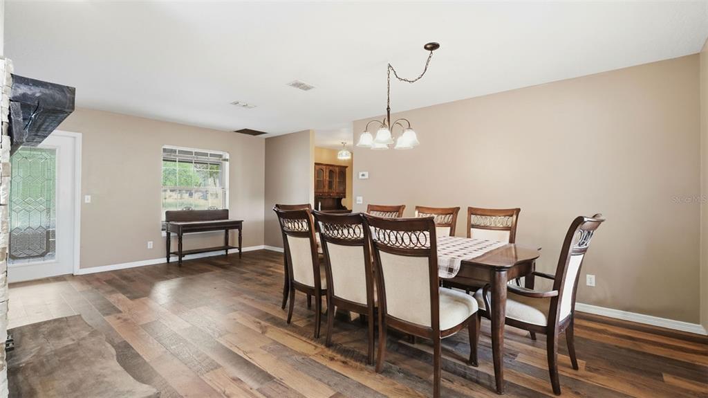 A dining room features a wooden table with six chairs, a chandelier, and wood flooring — 12092 S HYACINTH POINT, FLORAL CITY, FL