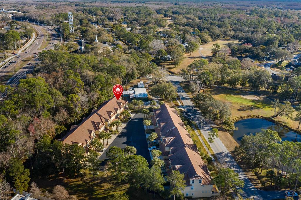 An aerial view shows two multi-story townhome buildings separated by a parking lot — 2676 TANGLEWOOD TRAIL, PALM HARBOR, FL