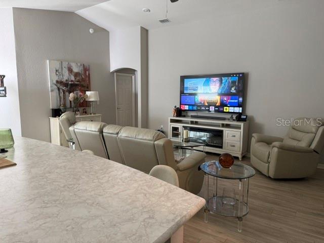 A living room features light-colored leather furniture, a television on a media console, and flooring — 1552 FLEUR DRIVE, DAVENPORT, FL