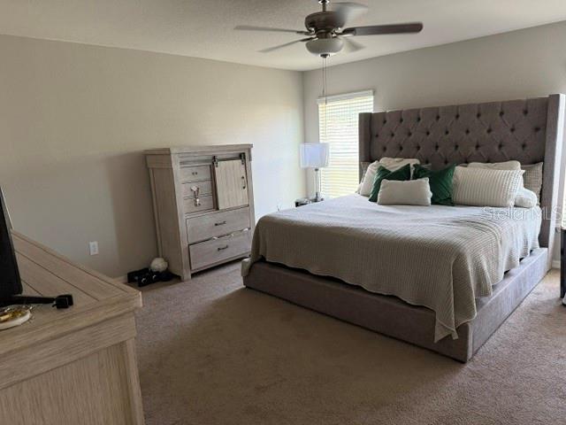 A bedroom features a large tufted headboard, a light wood dresser, and a ceiling fan — 1552 FLEUR DRIVE, DAVENPORT, FL
