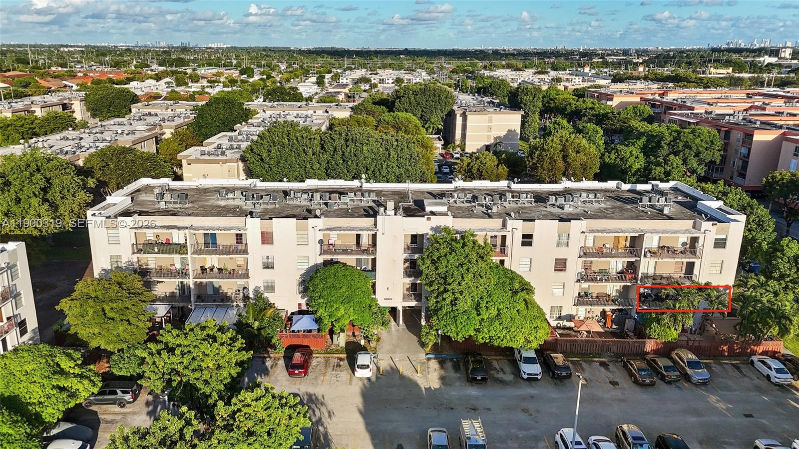 An aerial view shows a multi-story apartment building with a red-outlined balcony and parking — 5665 W 20th Ave # 212, Hialeah FL 33012, HIALEAH, FL
