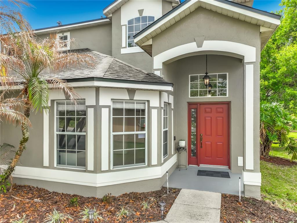 The exterior of a two-story house features a red front door and a bay window — 949 PICKFAIR TERRACE, LAKE MARY, FL