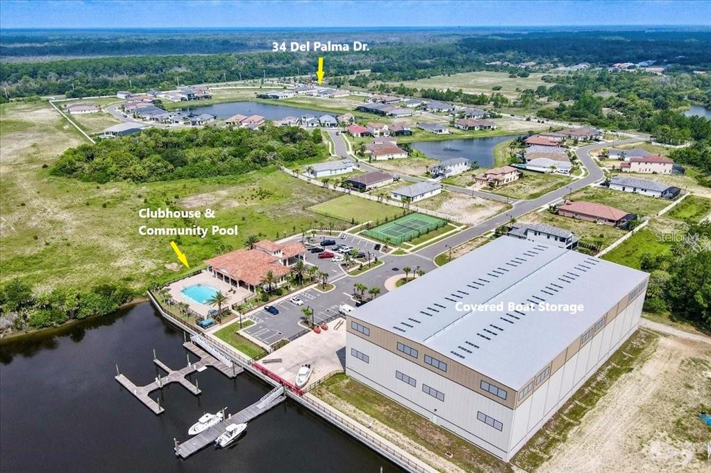 An aerial view shows a community clubhouse, pool, boat docks, and a large storage building — 34 DEL PALMA DRIVE, PALM COAST, FL