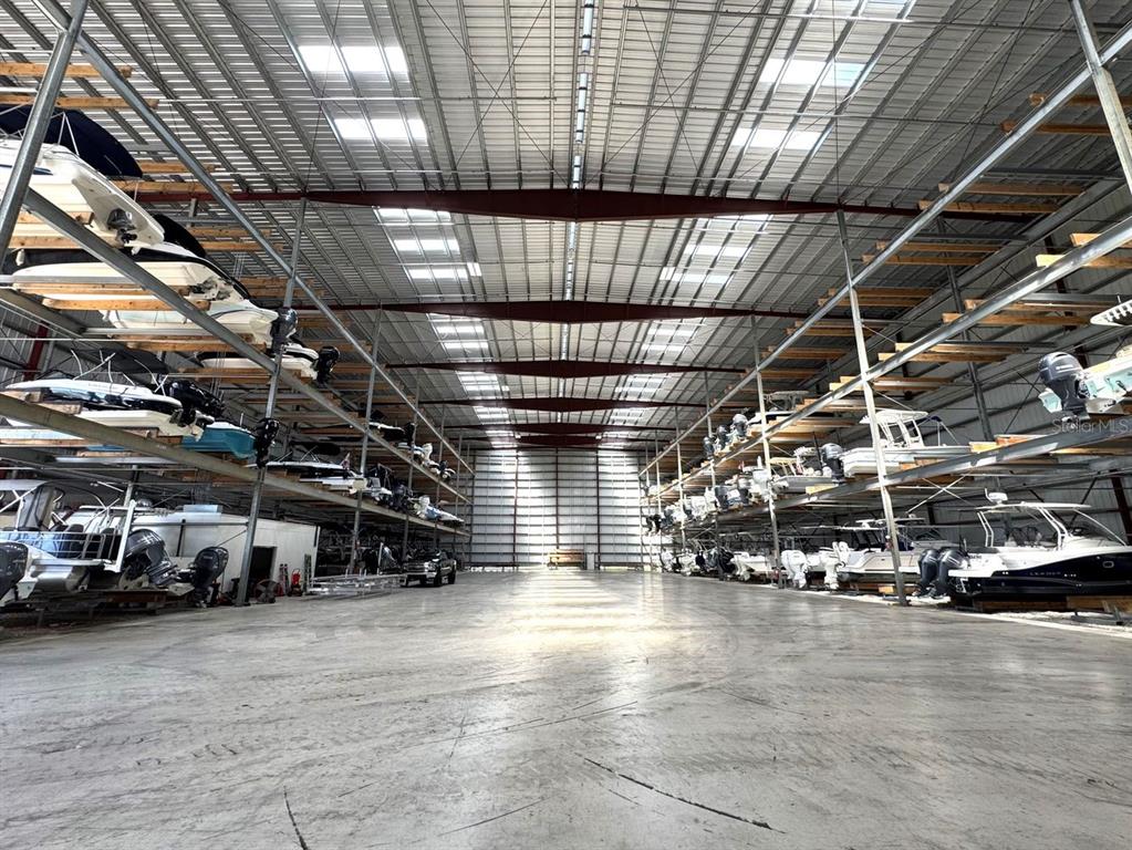 A large indoor boat storage facility with multi-level metal racking systems holding numerous boats — 34 DEL PALMA DRIVE, PALM COAST, FL