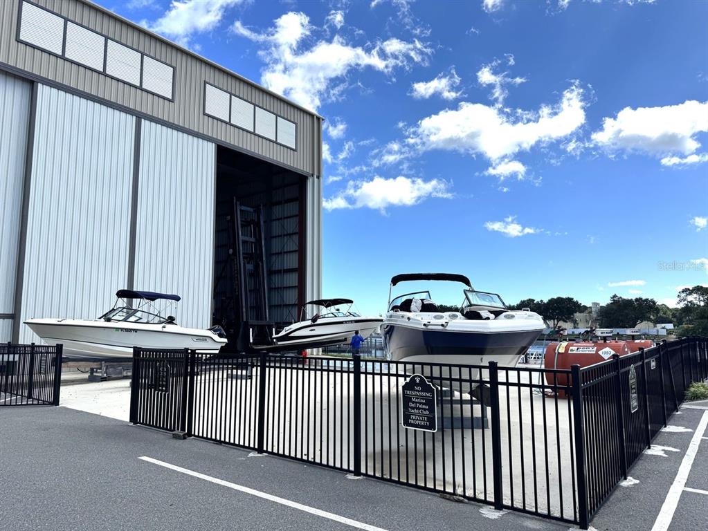 Three boats are parked on a concrete lot in front of a large metal building — 34 DEL PALMA DRIVE, PALM COAST, FL