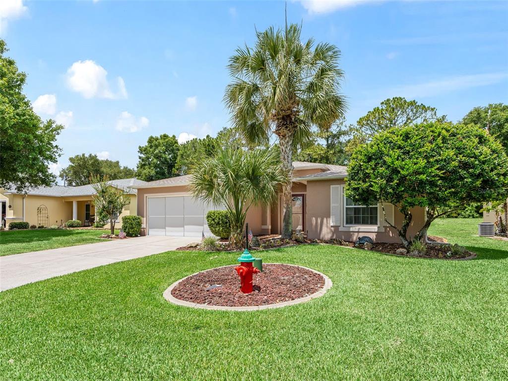 A single-story house with a tan exterior, a two-car garage, and a red fire hydrant — 15360 SW 15TH TERRACE ROAD, OCALA, FL