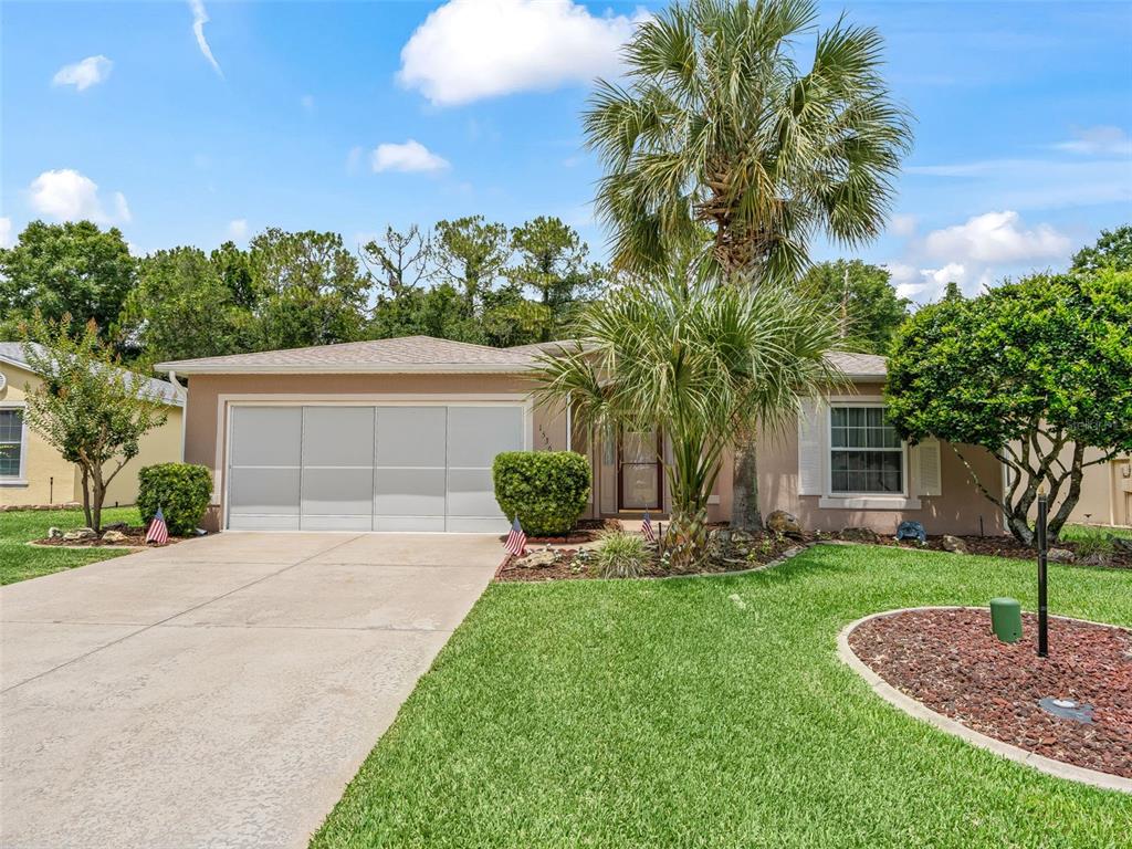 A single-story house with a concrete driveway, a two-car garage, and a palm tree — 15360 SW 15TH TERRACE ROAD, OCALA, FL