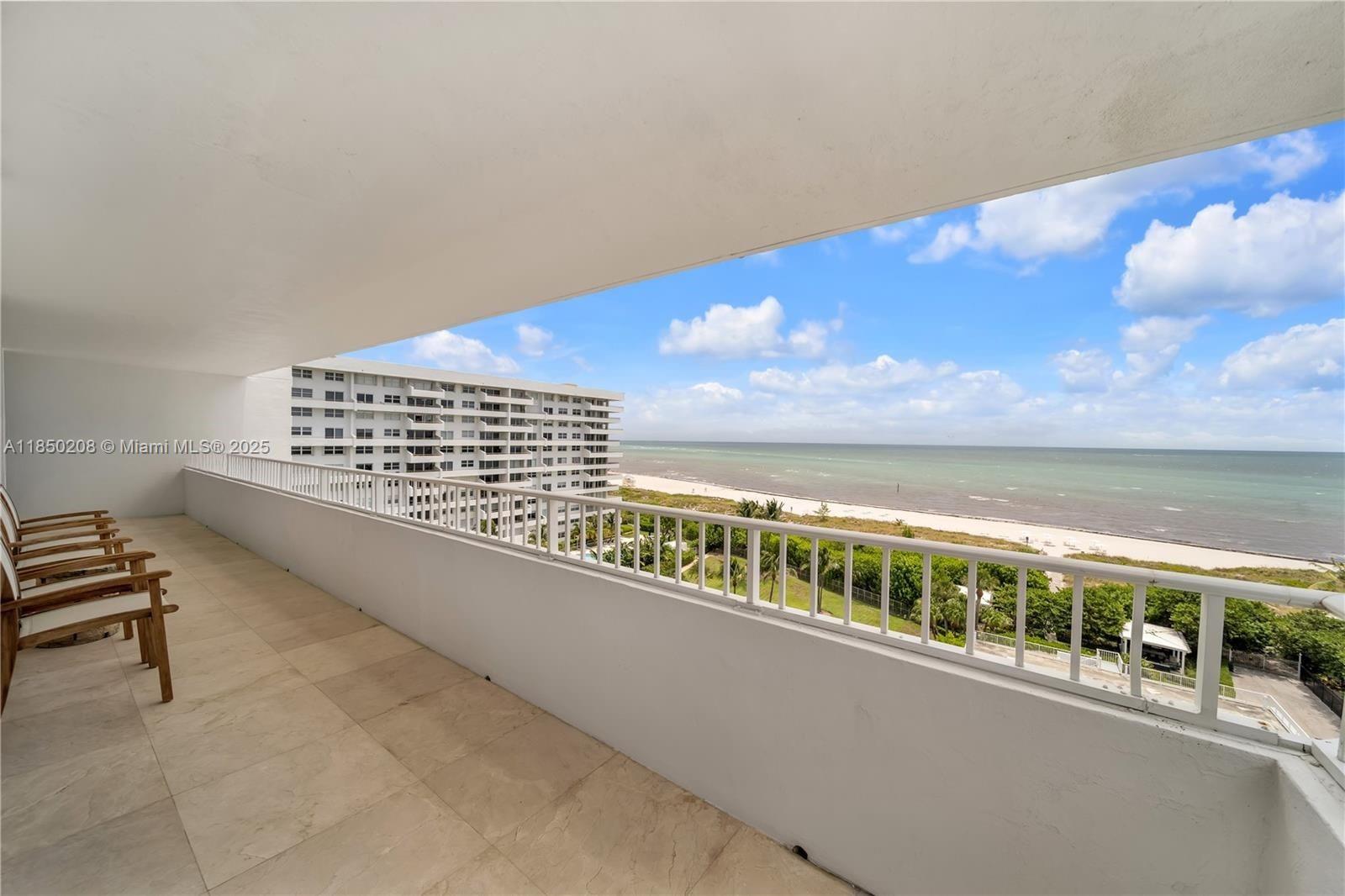 A balcony with tile flooring overlooks the ocean and a neighboring building — 199 Ocean Lane Dr # 901, Key Biscayne FL 33149, KEY BISCAYNE, FL