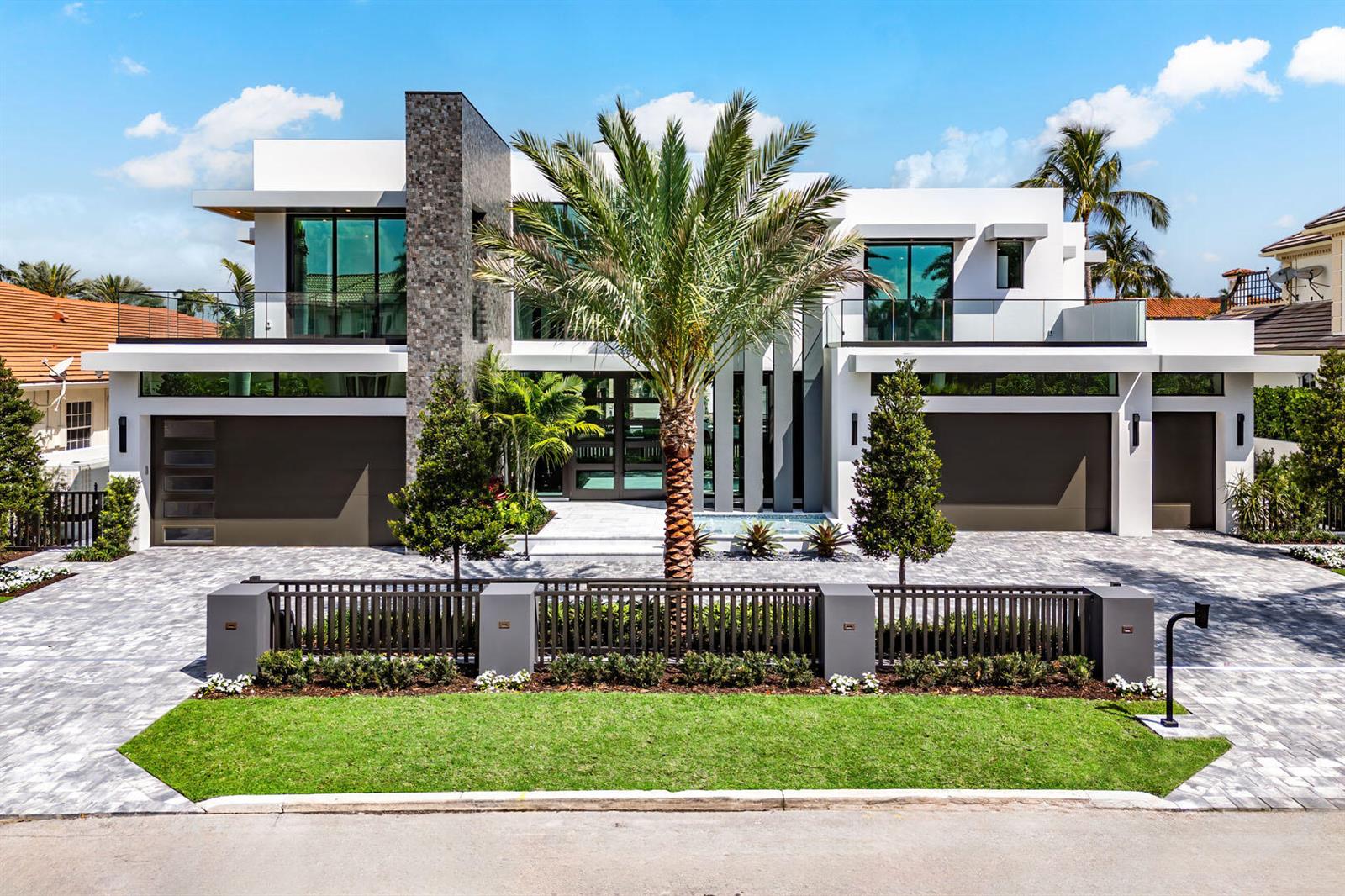 A modern two-story house with a palm tree, stone accent wall, and a gated driveway — 169 W Coconut Palm Road, Boca Raton FL 33432, BOCA RATON, FL