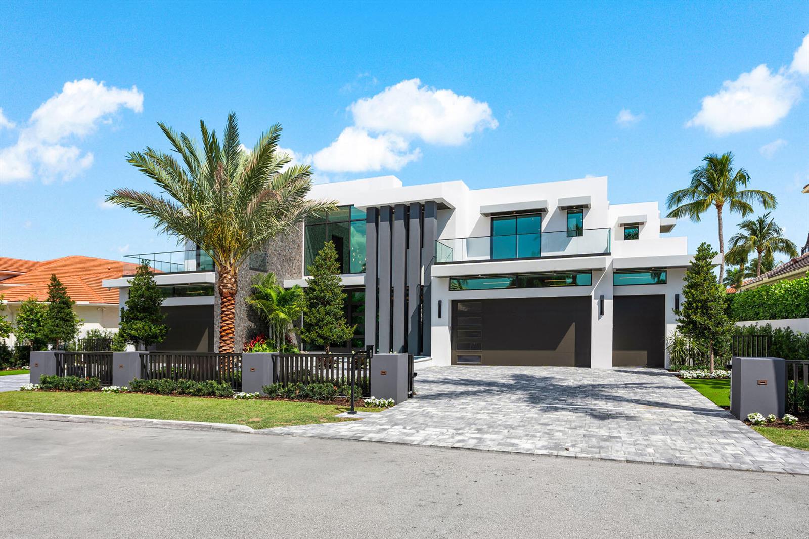 A modern two-story house with a stone facade, dark accents, and a paved driveway — 169 W Coconut Palm Road, Boca Raton FL 33432, BOCA RATON, FL