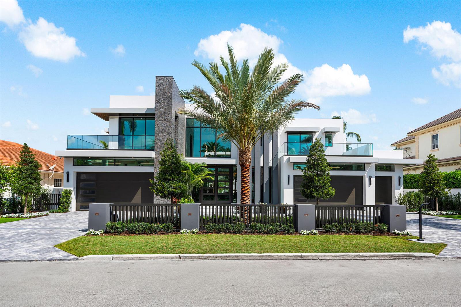 A modern two-story house with a stone facade, glass balconies, and a palm tree — 169 W Coconut Palm Road, Boca Raton FL 33432, BOCA RATON, FL
