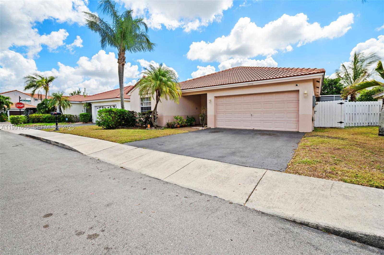 A single-story house with a beige exterior, a tiled roof, and a two-car garage — 12556 NW 10th Pl, Sunrise FL 33323, SUNRISE, FL