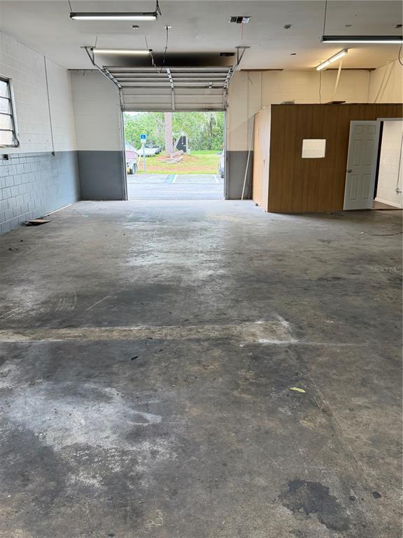 An interior view of a warehouse space with a concrete floor and an open bay door — 4500 NE 35TH STREET UNIT G-28, OCALA, FL