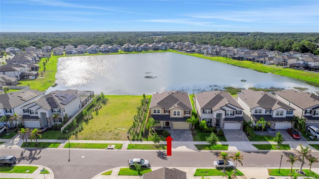 An aerial view shows a suburban neighborhood with a large lake and a highlighted house — 3091 MARINE GRASS DRIVE, WIMAUMA, FL
