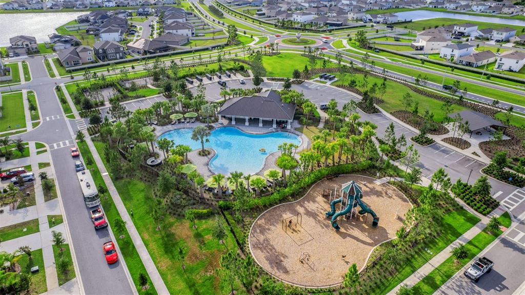 An aerial view of a community amenity center featuring a swimming pool and a playground — 3091 MARINE GRASS DRIVE, WIMAUMA, FL