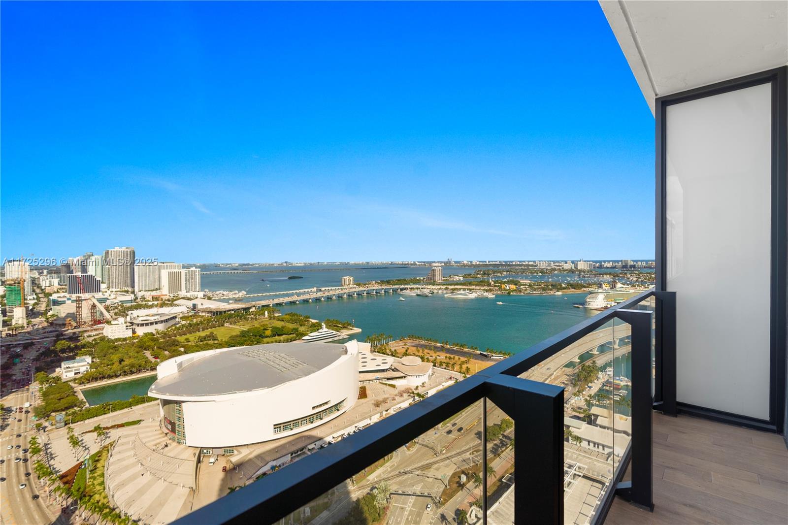 A high-rise balcony overlooks a large arena, a bridge, and a coastal cityscape — 398 NE 5th St # 3207, Miami FL 33132, MIAMI, FL