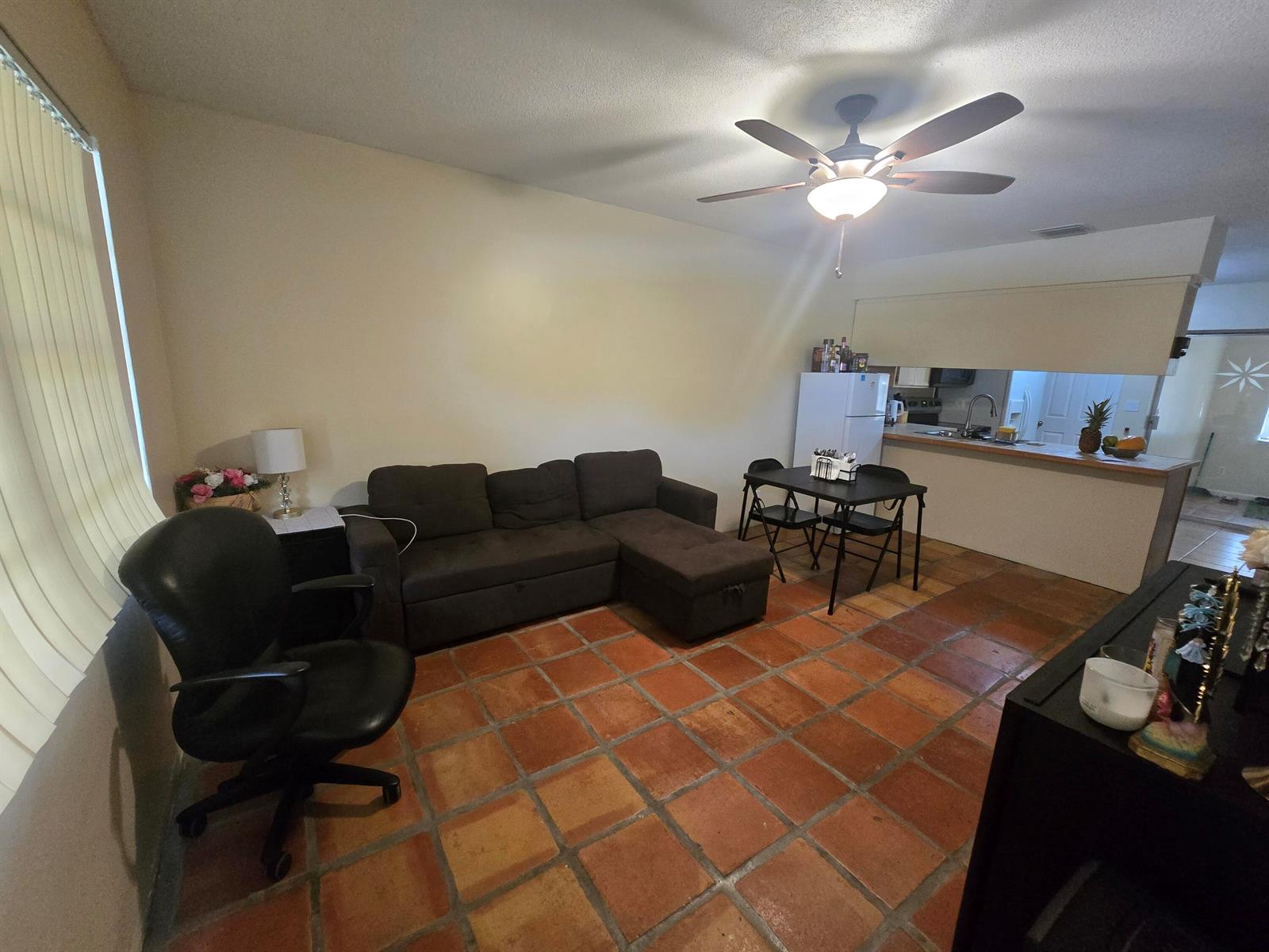 A living room with terracotta tile flooring, a dark sectional sofa, and a dining area — 3560 NW 3rd Avenue # 2, Pompano Beach FL 33064, POMPANO BEACH, FL