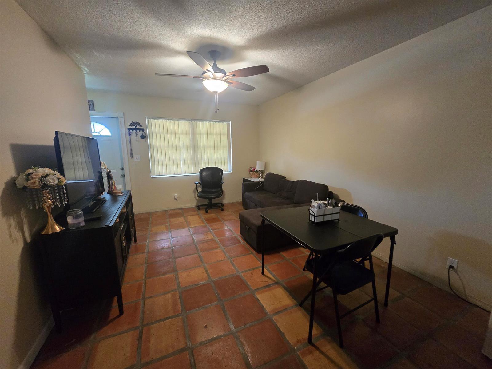 A living and dining area features terracotta tile flooring, a ceiling fan, and a sofa — 3560 NW 3rd Avenue # 2, Pompano Beach FL 33064, POMPANO BEACH, FL