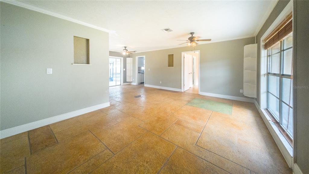 An interior view of a living room featuring large tan floor tiles and two ceiling fans — 3320 LAS BRISAS DRIVE, RIVERVIEW, FL