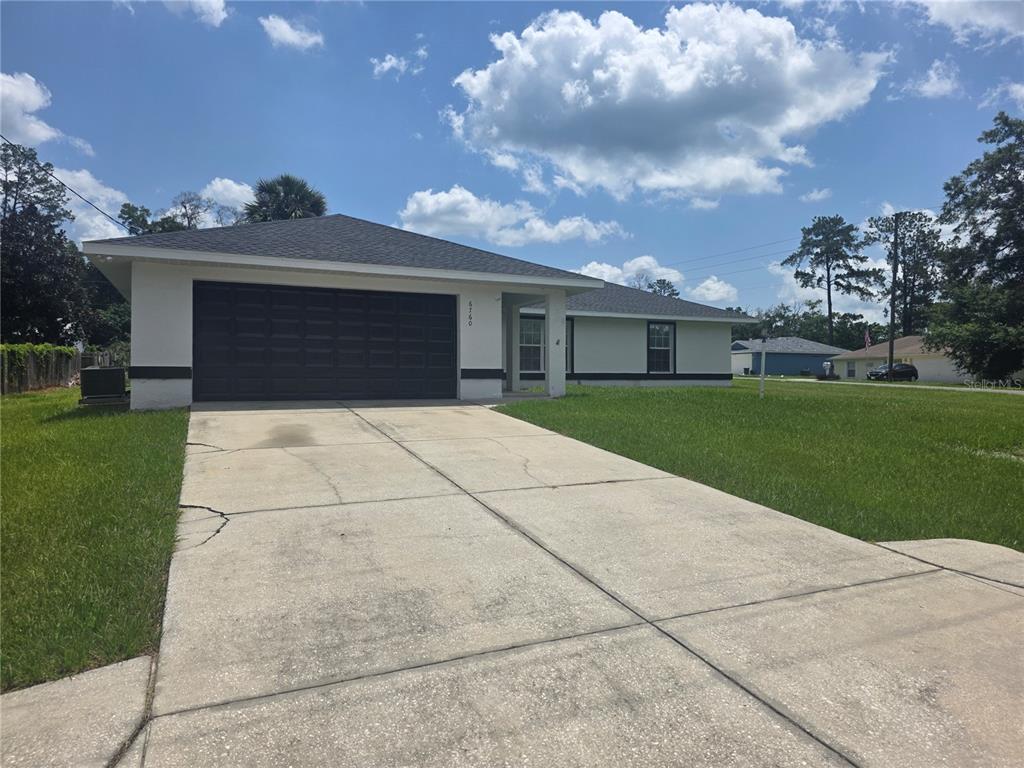 A single-story house with a two-car garage, a concrete driveway, and a light-colored exterior — 6760 CHERRY ROAD, OCALA, FL