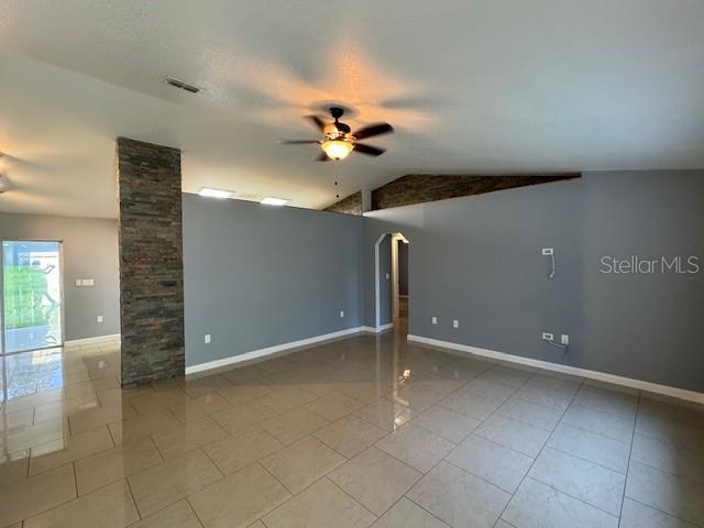 A living room features light-colored tile flooring, gray walls, and a stone-accented pillar — 6760 CHERRY ROAD, OCALA, FL
