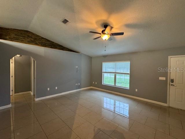 A living room with gray walls, light tile flooring, a ceiling fan, and a window — 6760 CHERRY ROAD, OCALA, FL