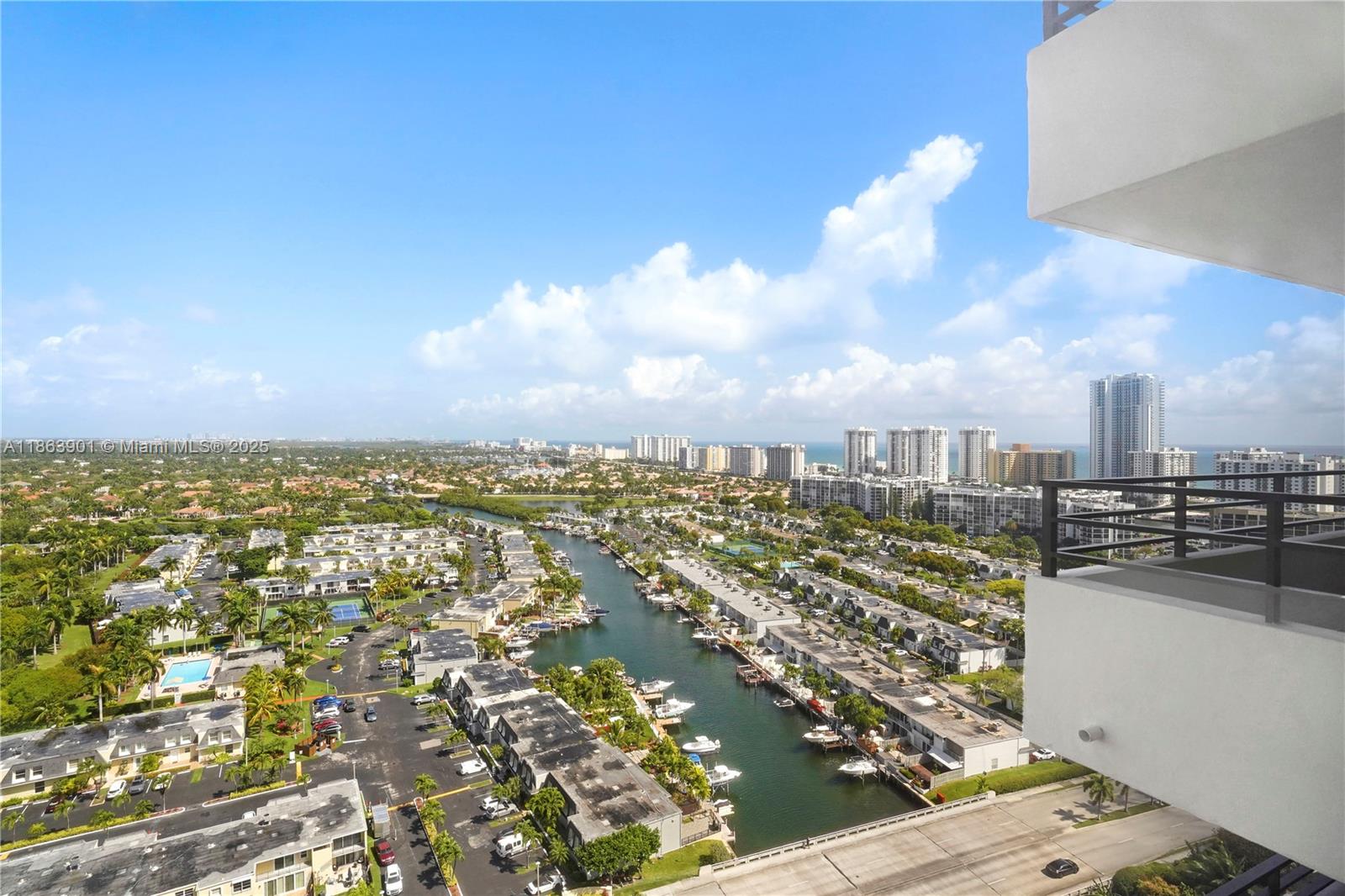 An elevated view shows a canal lined with townhomes and boats under a blue sky — 2500 Parkview Dr # 2408, Hallandale Beach FL 33009, HALLANDALE BEACH, FL
