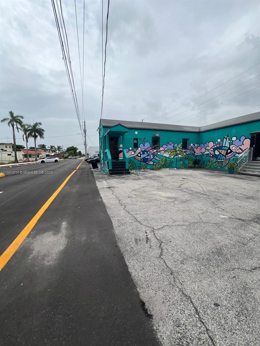 A teal building with a colorful mural stands next to an asphalt parking lot — 139 NE 1st Ave, Hallandale Beach FL 33009, HALLANDALE BEACH, FL