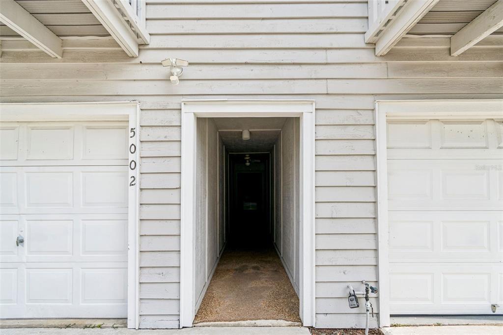 The exterior view shows a central entryway flanked by two white garage doors — 6437 93RD TERRACE N UNIT 5002, PINELLAS PARK, FL