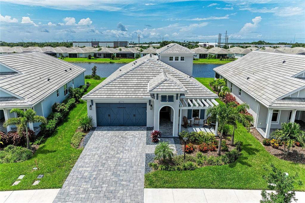 An aerial view of a single-story house with a gray tile roof and paved driveway — 8079 SLIPWAY DR, SARASOTA, FL