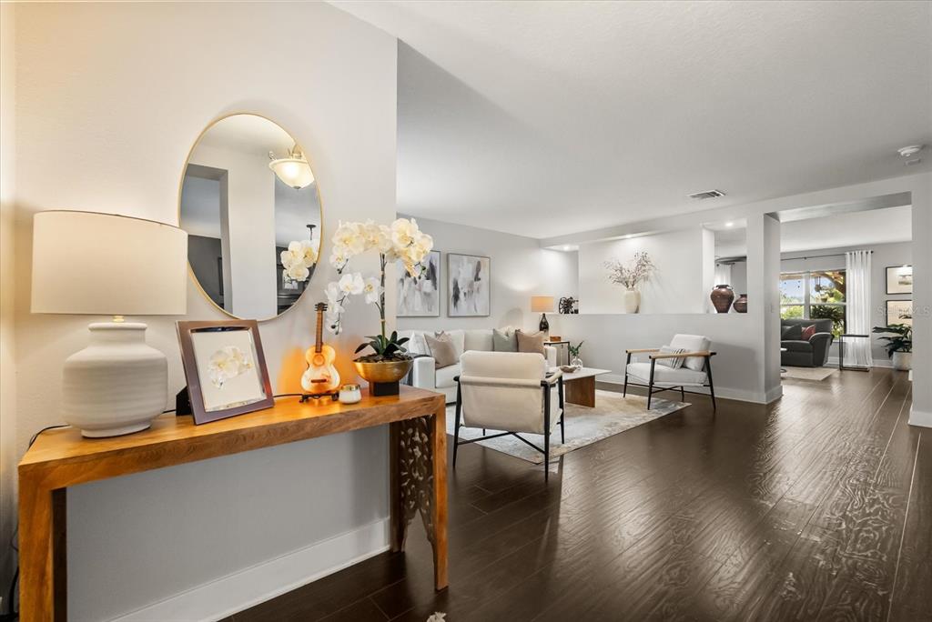 A wooden console table sits in a hallway overlooking a living room with hardwood floors — 13850 CAROLINA LAUREL DRIVE, ORLANDO, FL