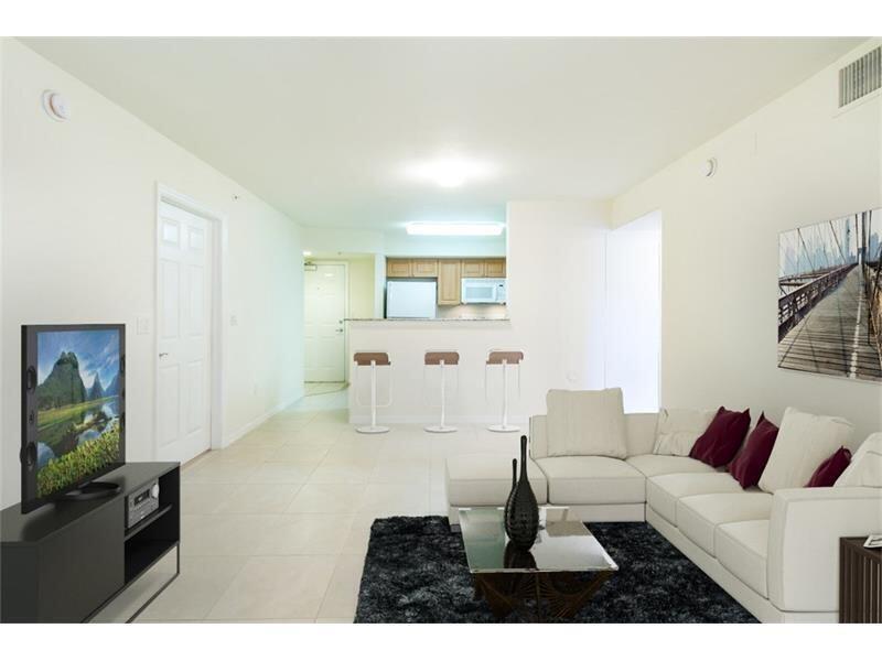 A living room with a white sectional sofa, a black rug, and an open kitchen — 6760 Heritage # 6103, Boynton Beach FL 33437, BOYNTON BEACH, FL
