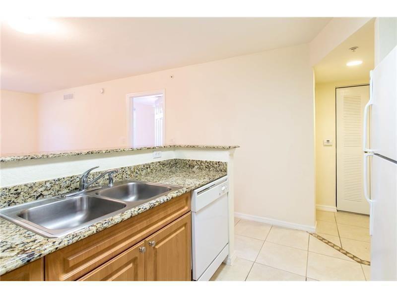 A kitchen features a double-basin stainless steel sink, granite countertops, and a white dishwasher — 6760 Heritage # 6103, Boynton Beach FL 33437, BOYNTON BEACH, FL