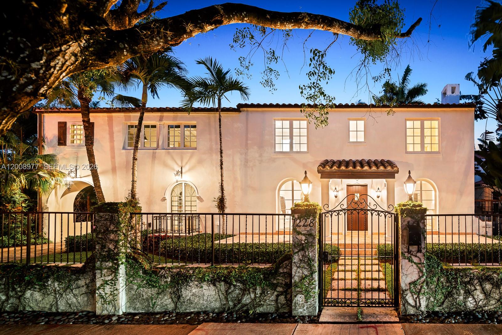 A white two-story house features a backyard with a swimming pool and palm trees — 1228 Alhambra Cir, Coral Gables FL 33134, CORAL GABLES, FL