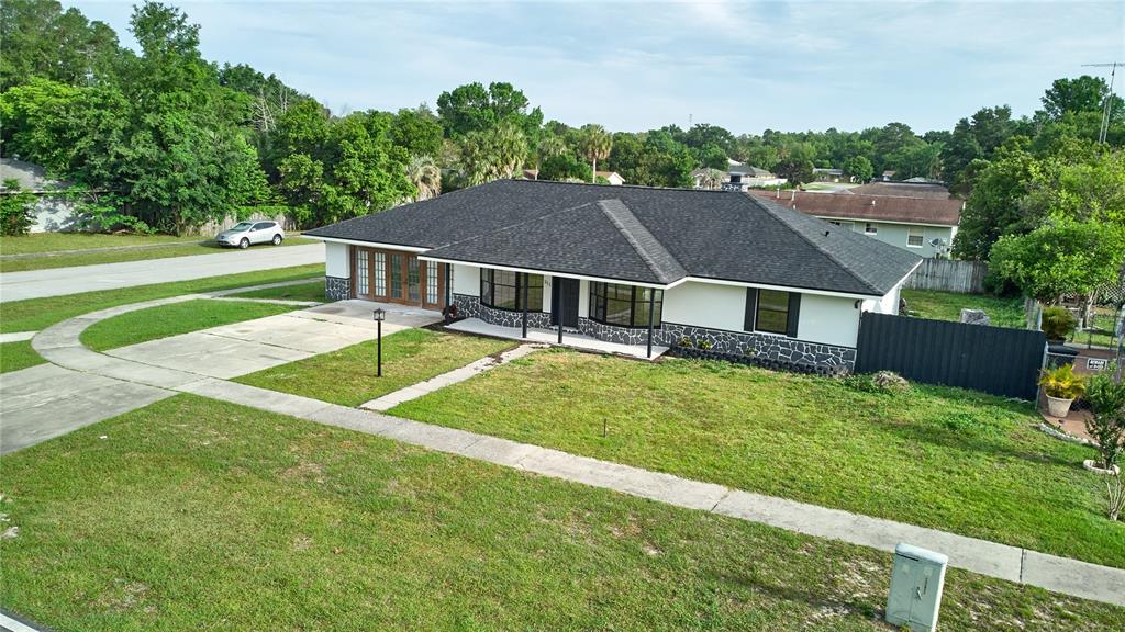 An aerial view of a single-story house with a dark roof and stone-accented exterior — 211 MARION OAKS LANE, OCALA, FL