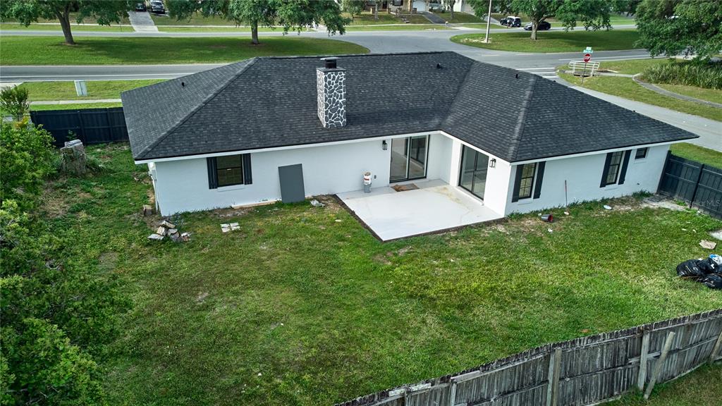 An aerial view shows the back of a white house with a dark roof and patio — 211 MARION OAKS LANE, OCALA, FL