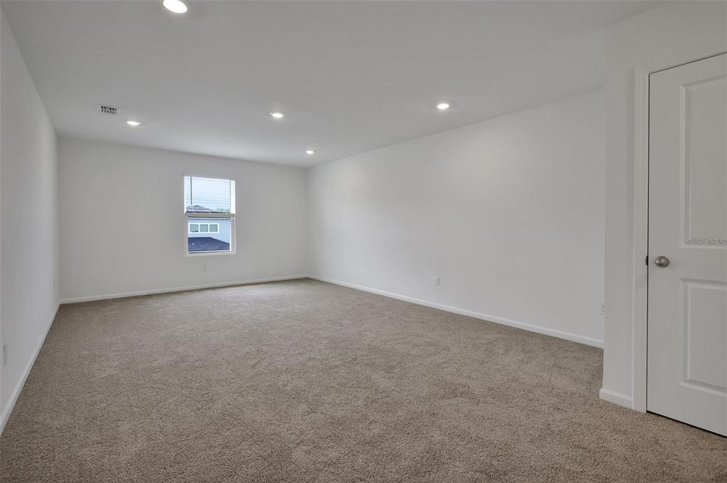 An empty room with white walls, beige carpet, recessed lighting, and a single window — 14367 FIREBIRD DRIVE, JACKSONVILLE, FL