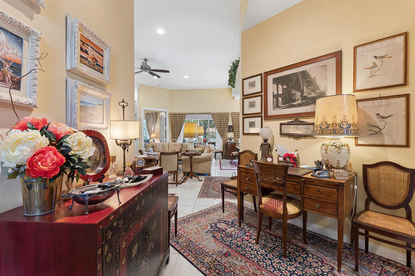 A foyer with a desk and a red cabinet leads into a bright living room — 2525 Kittbuck Way, West Palm Beach FL 33411, WEST PALM BEACH, FL