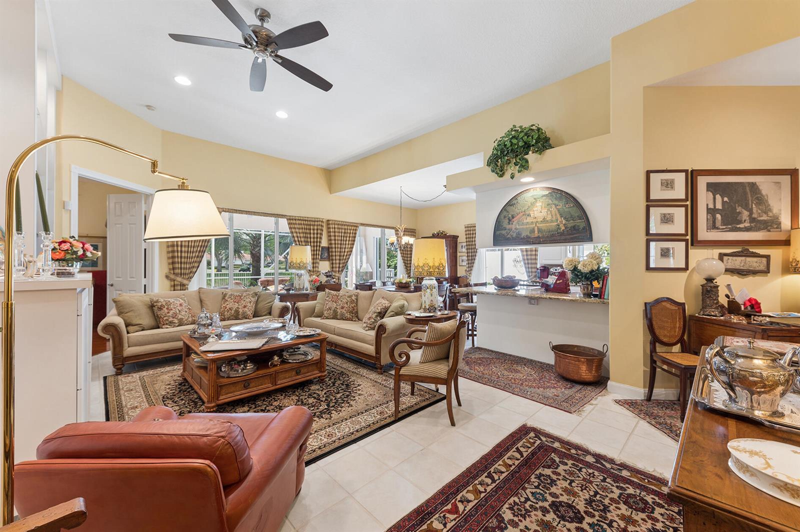 A living room features beige sofas, a coffee table, a ceiling fan, and tile flooring — 2525 Kittbuck Way, West Palm Beach FL 33411, WEST PALM BEACH, FL