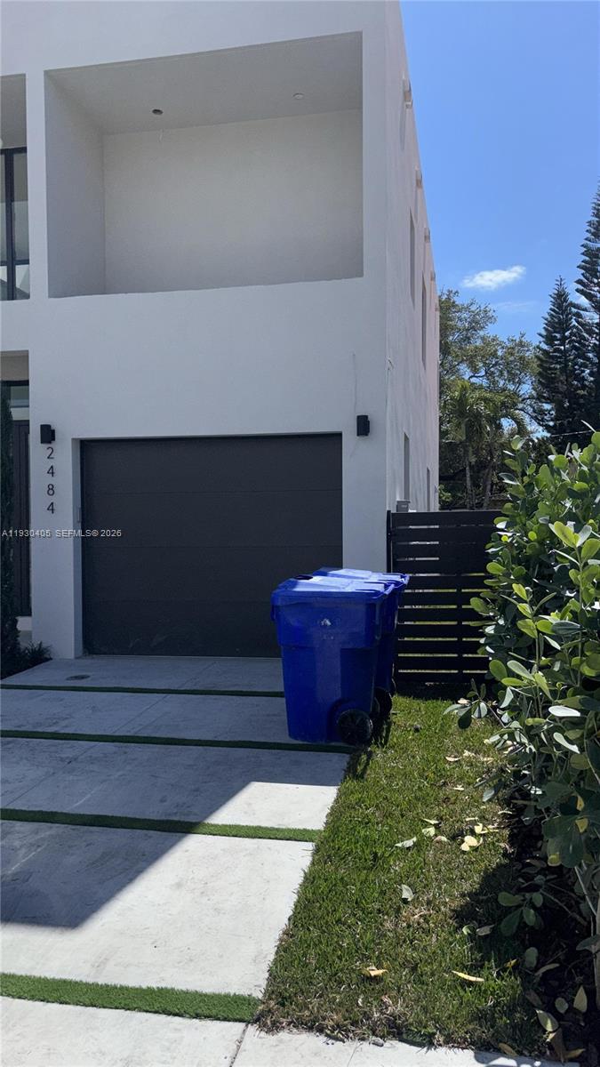 A modern two-story house exterior features a gray garage door and two blue trash bins — 2484 SW 18th St, Miami FL 33145, MIAMI, FL