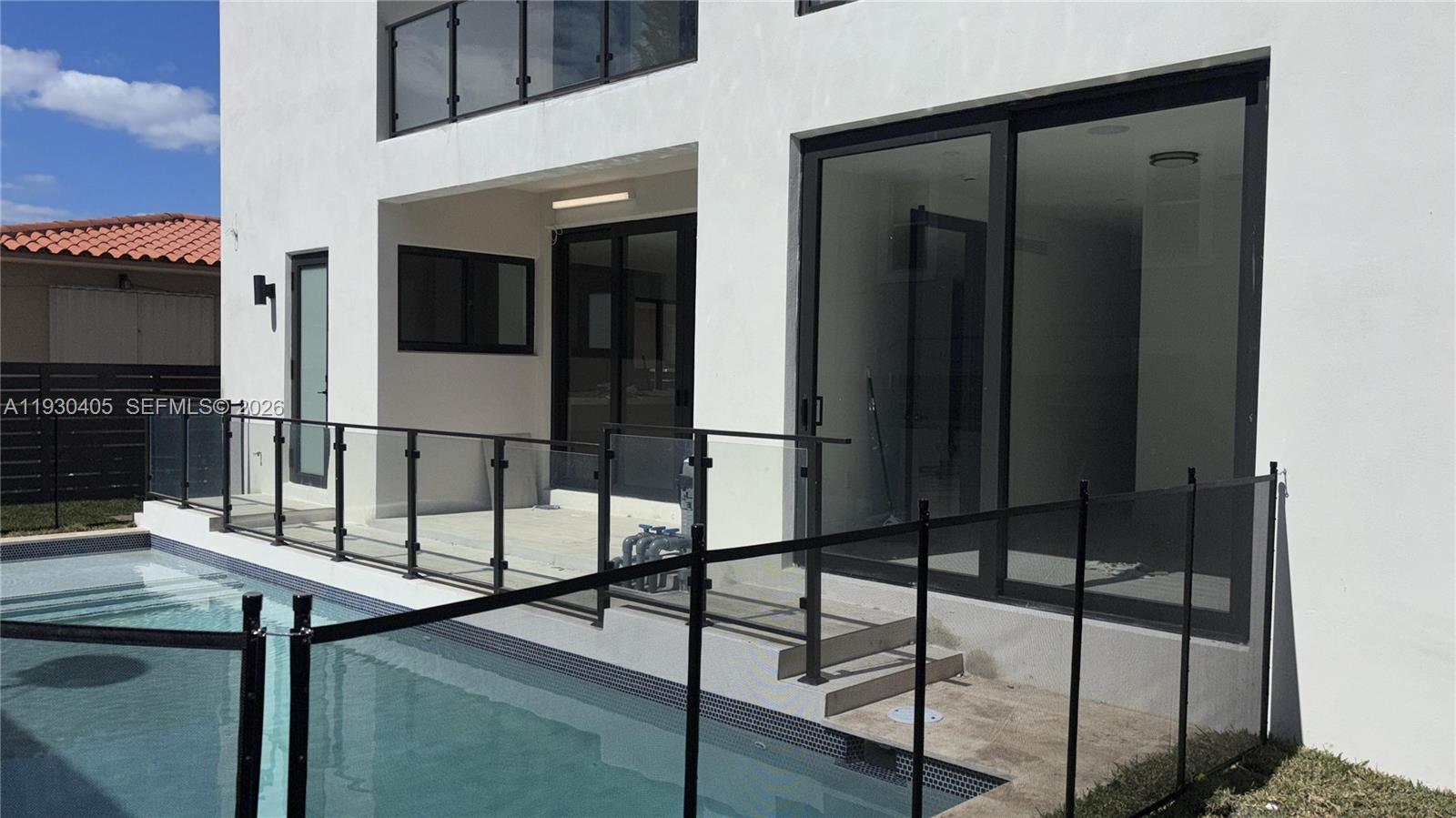 A white modern house exterior features a pool, glass railings, and large sliding glass doors — 2484 SW 18th St, Miami FL 33145, MIAMI, FL