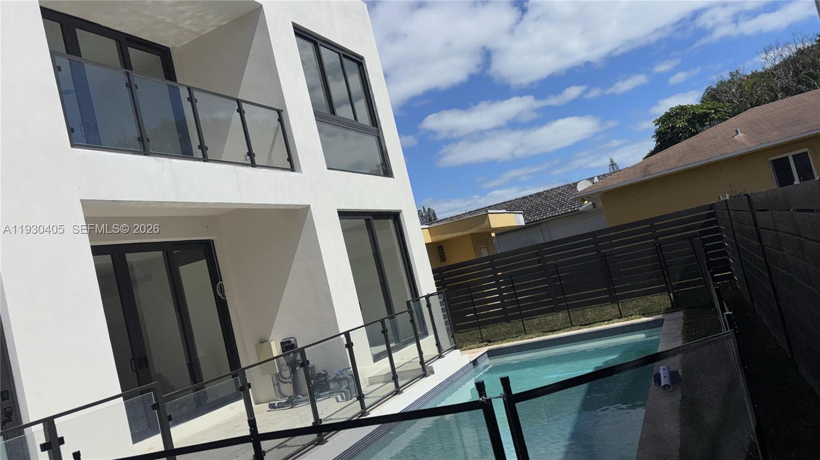 A modern white two-story house features a swimming pool and a glass-railed patio area — 2484 SW 18th St, Miami FL 33145, MIAMI, FL