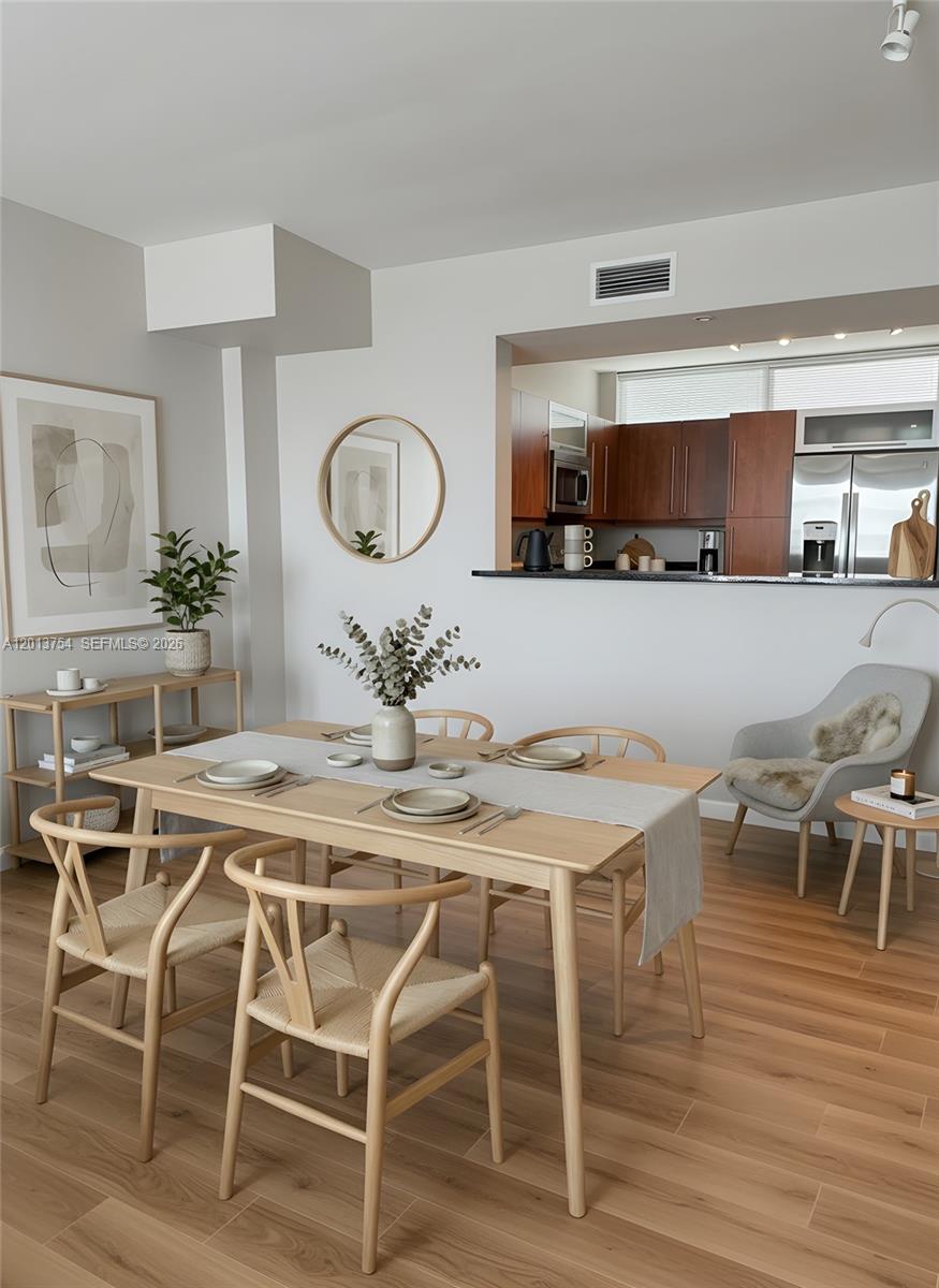 A dining area features a light wood table, woven chairs, and an open kitchen pass-through — 7350 SW 89th St # 1506S, Miami FL 33156, MIAMI, FL