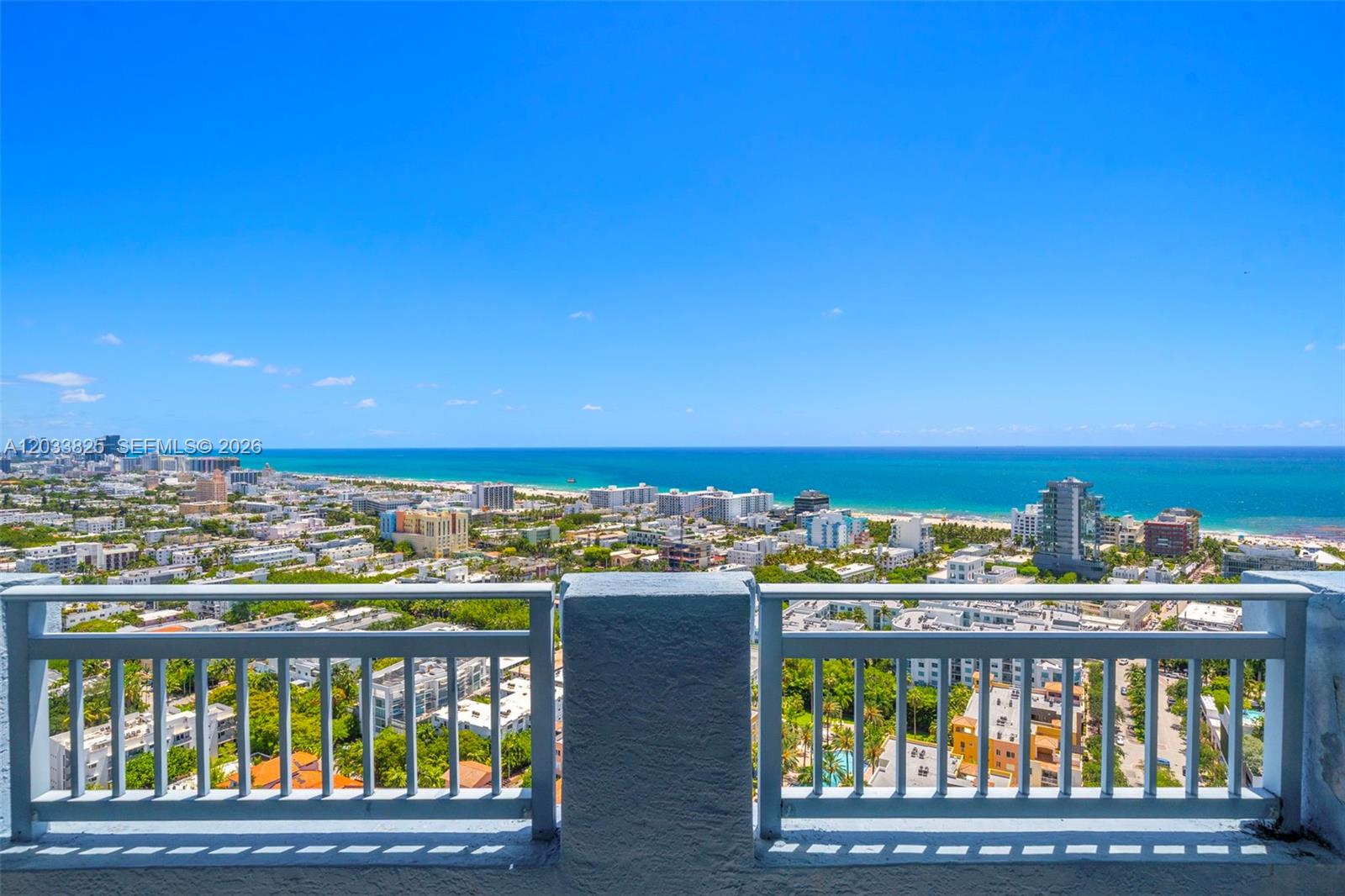 A balcony with a white railing overlooks a coastal city and the ocean — 90 Alton Rd, Miami Beach FL 33139, MIAMI BEACH, FL